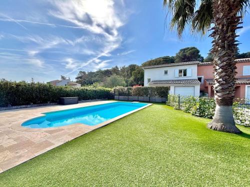 une piscine dans une cour avec un palmier dans l'établissement Maison de Vacance La Belle, à Sainte-Maxime