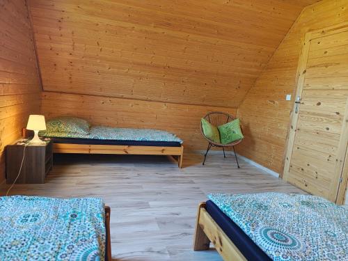 een kamer met 2 bedden en een stoel in een cabine bij Domki Milena in Mieroszyno