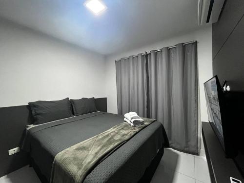 a bedroom with a bed in a room with a window at Bee Guest - Apartamentos de Temporada Luxxor Flat in Cuiabá