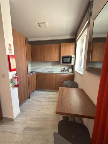 a room with a kitchen with a table and chairs at The Urban Suites in Il-Gżira