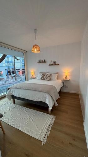 a bedroom with a large bed and a large window at Escale à Trafaria in Trafaria