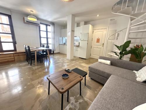 a living room with a couch and a table at Colcha Suites - Duplex Penthouse in Granada