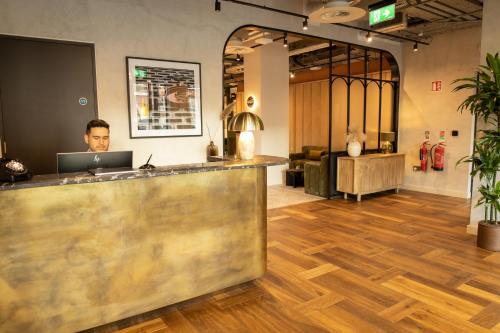 a man sitting at a counter with a laptop at Niche Living Ballsbridge in Dublin