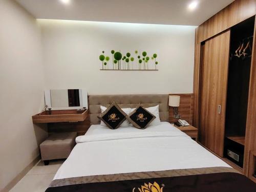a bedroom with a white bed and a television at Sen Vàng Luxury Hotel in Nha Trang