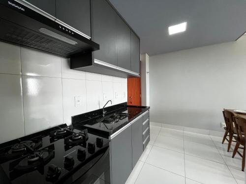 a kitchen with a stove and a counter top at Bee Guest - Apartamentos de Temporada Luxxor Flat in Cuiabá