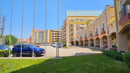 a blue car parked in a parking lot next to buildings at Boho Breeze Aheloy in Aheloy