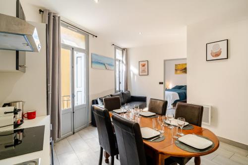 une cuisine et une salle à manger avec une table et des chaises dans l'établissement Cocon élégant en plein centre de Perpignan, à Perpignan