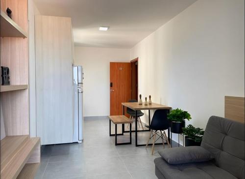 a living room with a table and a couch at Bee Guest - Apartamentos de Temporada Luxxor Flat in Cuiabá