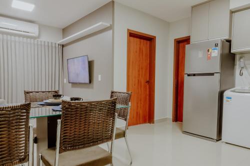 a kitchen with a table and chairs and a refrigerator at Bee Guest - Apartamentos de Temporada Luxxor Flat in Cuiabá