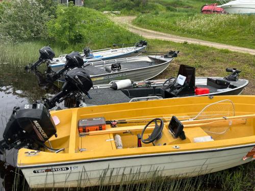 a yellow boat sitting in the water next to other boats at Tarula Holiday Home in Melkoniemi
