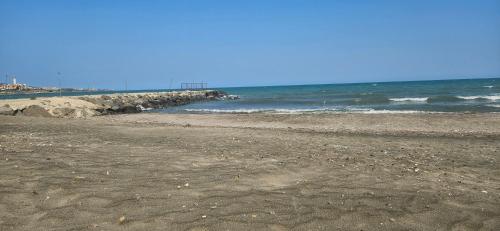 an empty beach with the ocean and a pier at Boho Breeze Aheloy in Aheloy