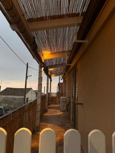 a balcony with a pergola and white chairs at Dafne Accomodation in Fitili