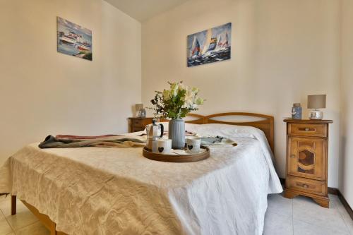 a bedroom with a bed with a table with flowers on it at Appartamento Casa Ledio - Theater Home in Tignale