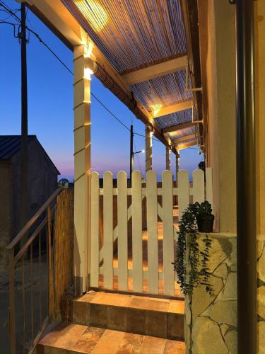 a white fence on a porch with a fence at Dafne Accomodation in Fitili