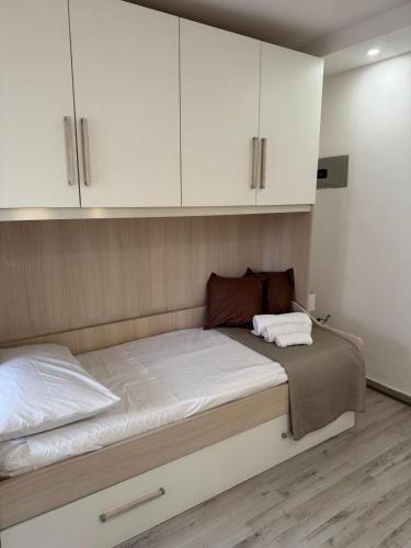 a bedroom with a bed with white cabinets at Dafne Accomodation in Fitili