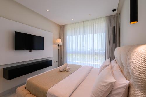 a bedroom with a bed and a flat screen tv at Royal Suite Caesarea in Caesarea