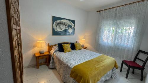 a bedroom with a bed and two lamps and a window at MEDDAYS Villa MARINA in Miami Platja
