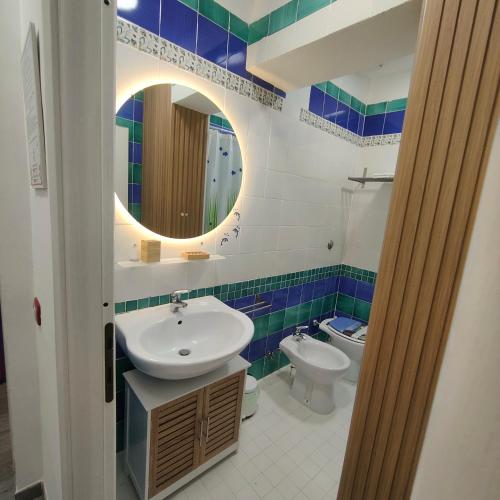a bathroom with a sink and a toilet and a mirror at Coral Rooms in Torre del Greco