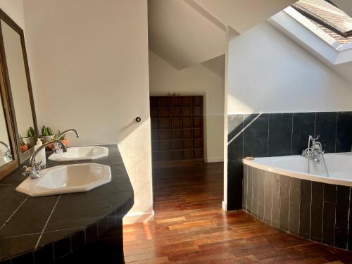 ein Badezimmer mit zwei Waschbecken und einer Badewanne in der Unterkunft Les écuries du château in Boissy-Saint-Léger