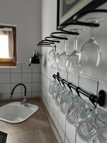 a bunch of wine glasses hanging on a wall at Nefelejcs-el vendeghaz in Balatonmáriafürdő