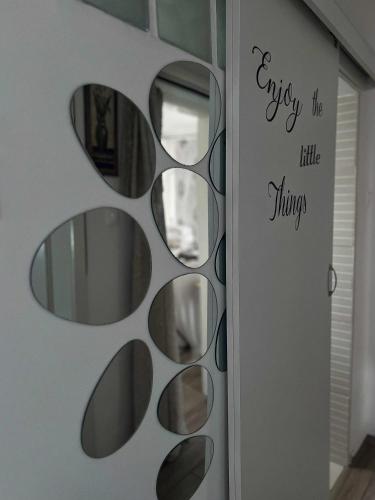 a wall with a mirror with the words enjoy the little little things at Nefelejcs-el vendeghaz in Balatonmáriafürdő