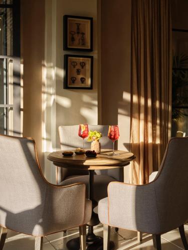 a table with two chairs and a table with flowers on it at Collegio alla Querce, Auberge Collection in Florence