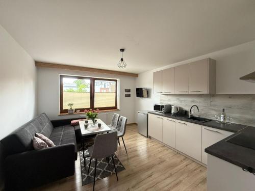 a kitchen and living room with a couch and a table at Apartamenty Wadowity- Energylandia Zator in Wadowice