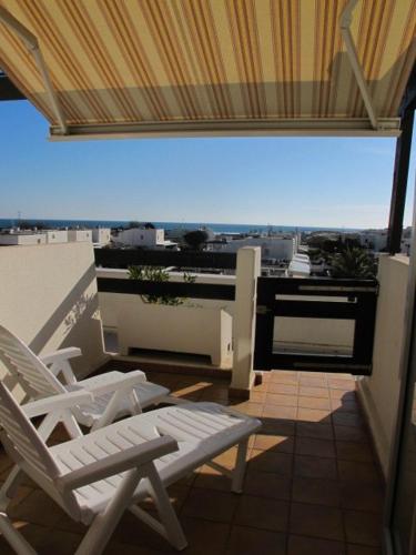 un balcon avec deux chaises et une vue sur une ville dans l'établissement Studio Port Nature PN87- 2 personnes, au Cap d'Agde