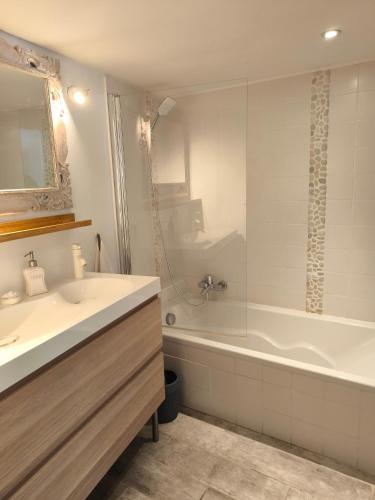 une salle de bain avec une baignoire et un lavabo et une baignoire dans l'établissement Ma maison aux Angles calme climatisée, aux Angles (Gard)