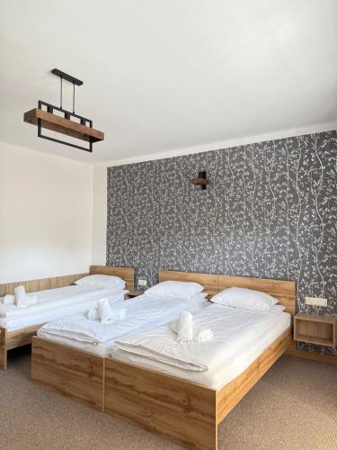 two twin beds in a room with a wall at Apartamenty Wadowity- Energylandia Zator in Wadowice