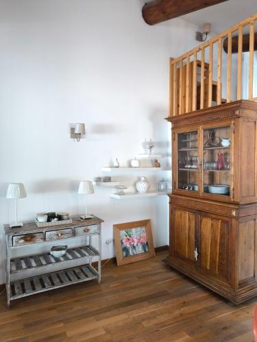 Cette chambre comprend une armoire en bois et une table. dans l'établissement Ma maison aux Angles calme climatisée, aux Angles (Gard)