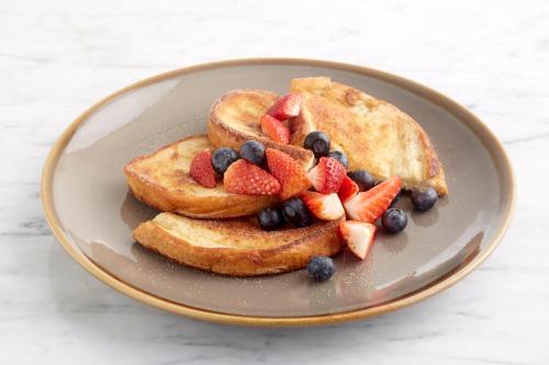 a plate of pancakes with fruit on top at Holiday Inn Birmingham M6, Jct7 by IHG in Birmingham