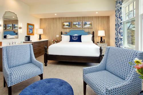 a bedroom with a bed and two chairs at The Inn at Stonecliffe in Mackinac Island