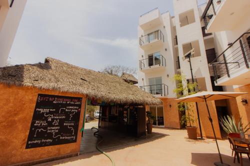 a restaurant with a thatch roof and a menu on a building at Viajero Sayulita Hostel in Sayulita