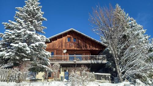 une cabane en rondins dans la neige avec des arbres dans l'établissement Le chalet montagnard Ninou, aux Angles