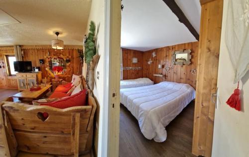une chambre avec un lit et un salon dans l'établissement Le chalet montagnard Ninou, aux Angles