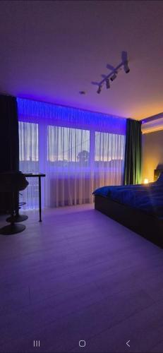 a bedroom with a bed and a table and purple lighting at RVR Apartmanhàz in Sárospatak