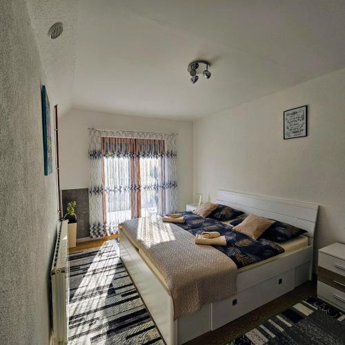 a bedroom with a large bed in front of a window at Apartment Topalovic Plitvice Private Pool in Korenica