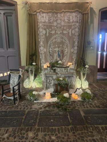 a room with a altar with flowers and candles at Aghinas in Bosa