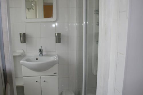 une salle de bain blanche avec un lavabo et une douche dans l'établissement Phil34, à Valergues