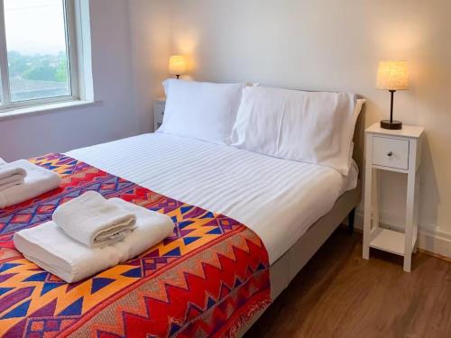 a bedroom with a bed with white sheets and a window at Sleeps2-FreeParking-ContactlessCheckIn-Glastonbury in Glastonbury