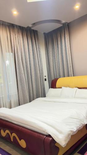 a large bed in a room with a window at Silver Homes Empiror in Kampala