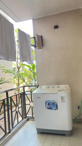 a white refrigerator sitting on top of a balcony at Silver Homes Empiror in Kampala