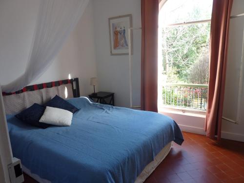 une chambre avec un lit bleu et une fenêtre dans l'établissement Maison à Ste Colombe, à La Celle-sous-Gouzon