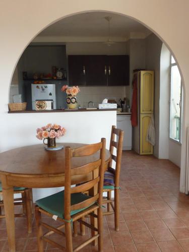 Il comprend une cuisine équipée d'une table et de chaises. dans l'établissement Maison à Ste Colombe, à La Celle-sous-Gouzon