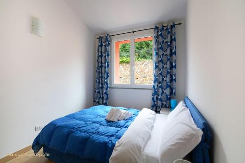 a bedroom with a blue bed and a window at Borgo dei Fiori - Sea Spa & Pool in Magliolo
