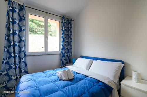 a bedroom with a blue bed and a window at Borgo dei Fiori - Sea Spa & Pool in Magliolo