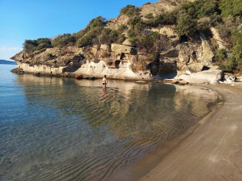a person standing in the water at the beach at Aghinas in Bosa