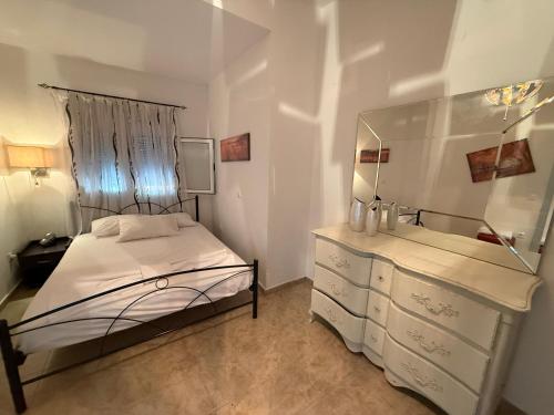 a bedroom with a bed and a dresser with a mirror at Silot apartment 5 in Nea Fokea