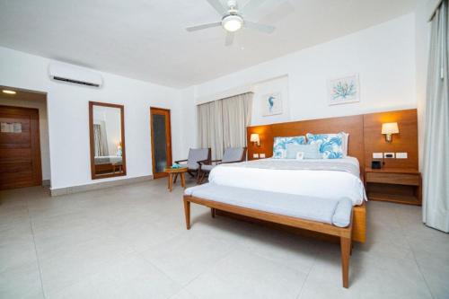 a bedroom with a large bed with blue pillows at Presidential Suites Cabarete - Room Only in Cabarete